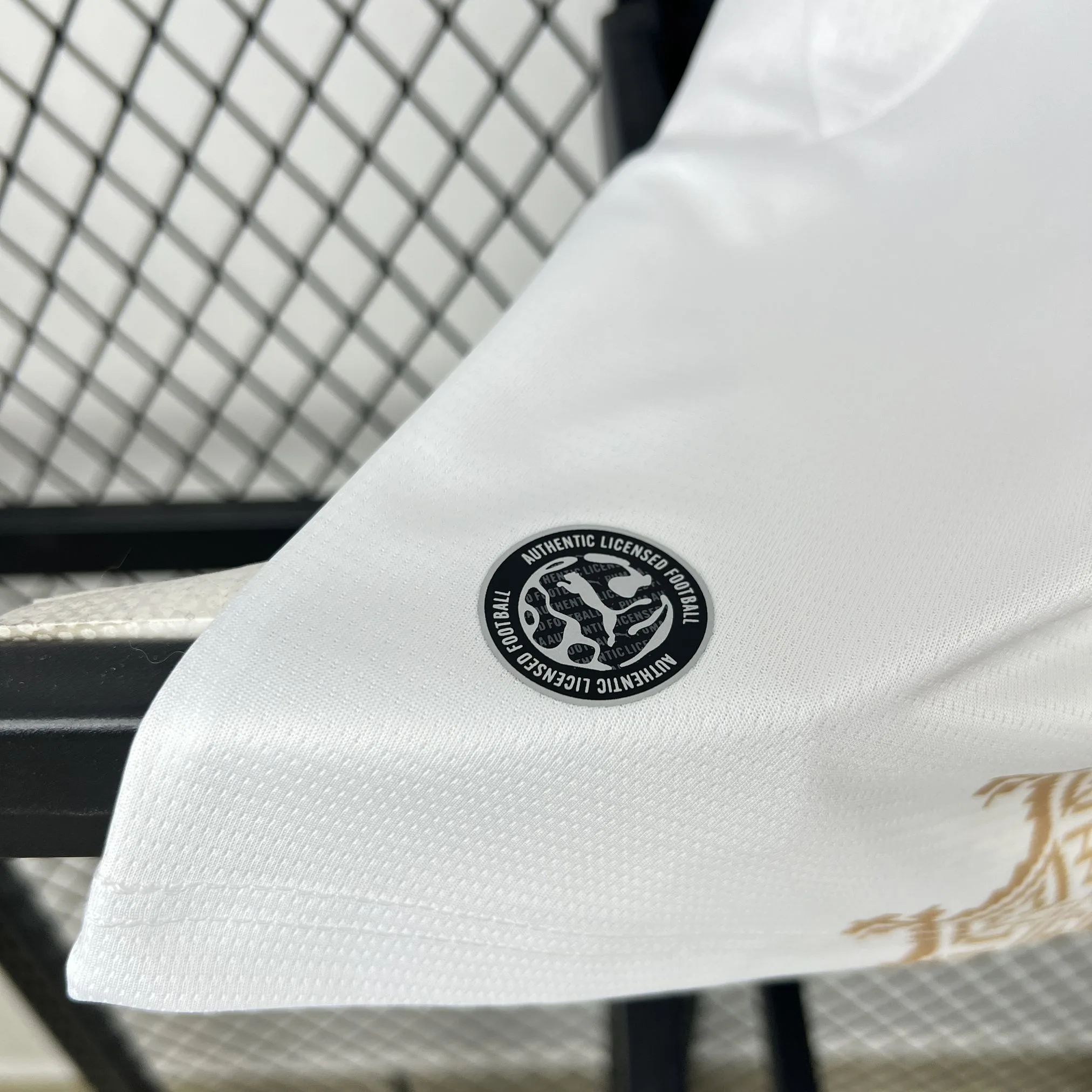 Detalle del sello de autenticidad y producto licenciado en el lateral inferior de la camiseta de Marruecos.