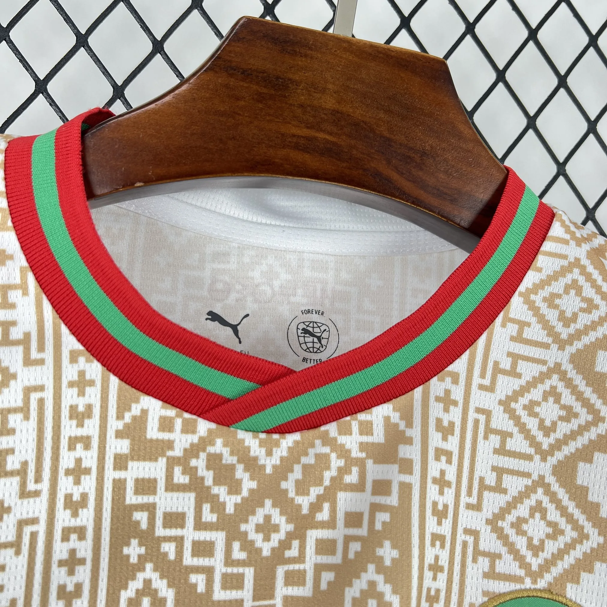 Detalle del cuello redondo blanco con finos acabados en verde y rojo de la segunda equipación de Marruecos.