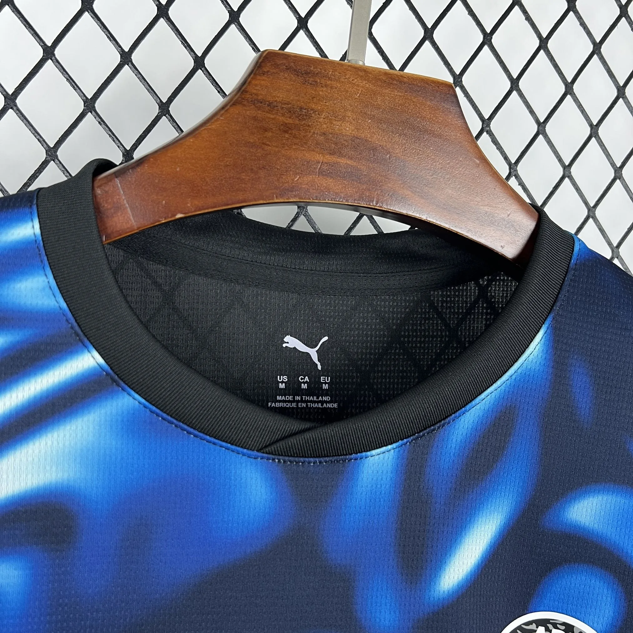 Vista del cuello redondo azul con vivos rojos y detalles técnicos impresos en el interior de la camiseta.