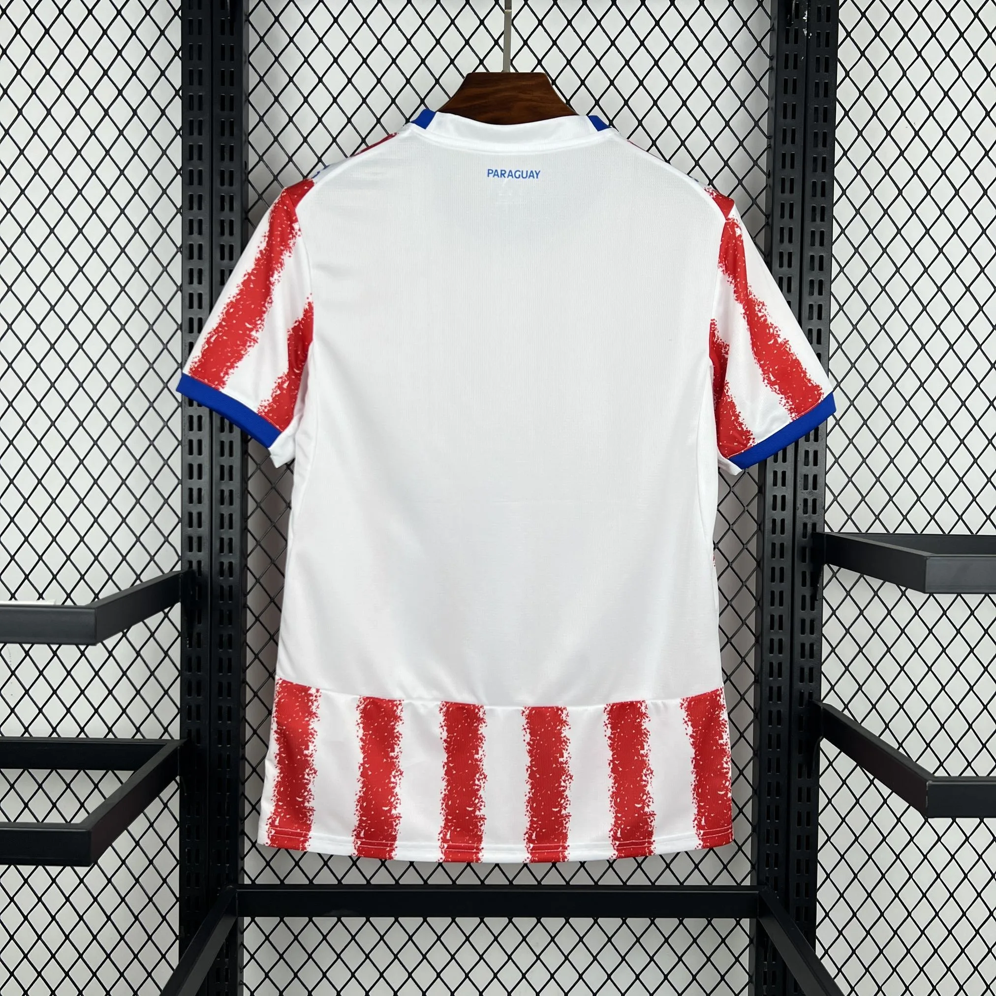 Vista posterior de la camiseta de Paraguay para el Mundial 2026, con predominio de franjas rojas y blancas.