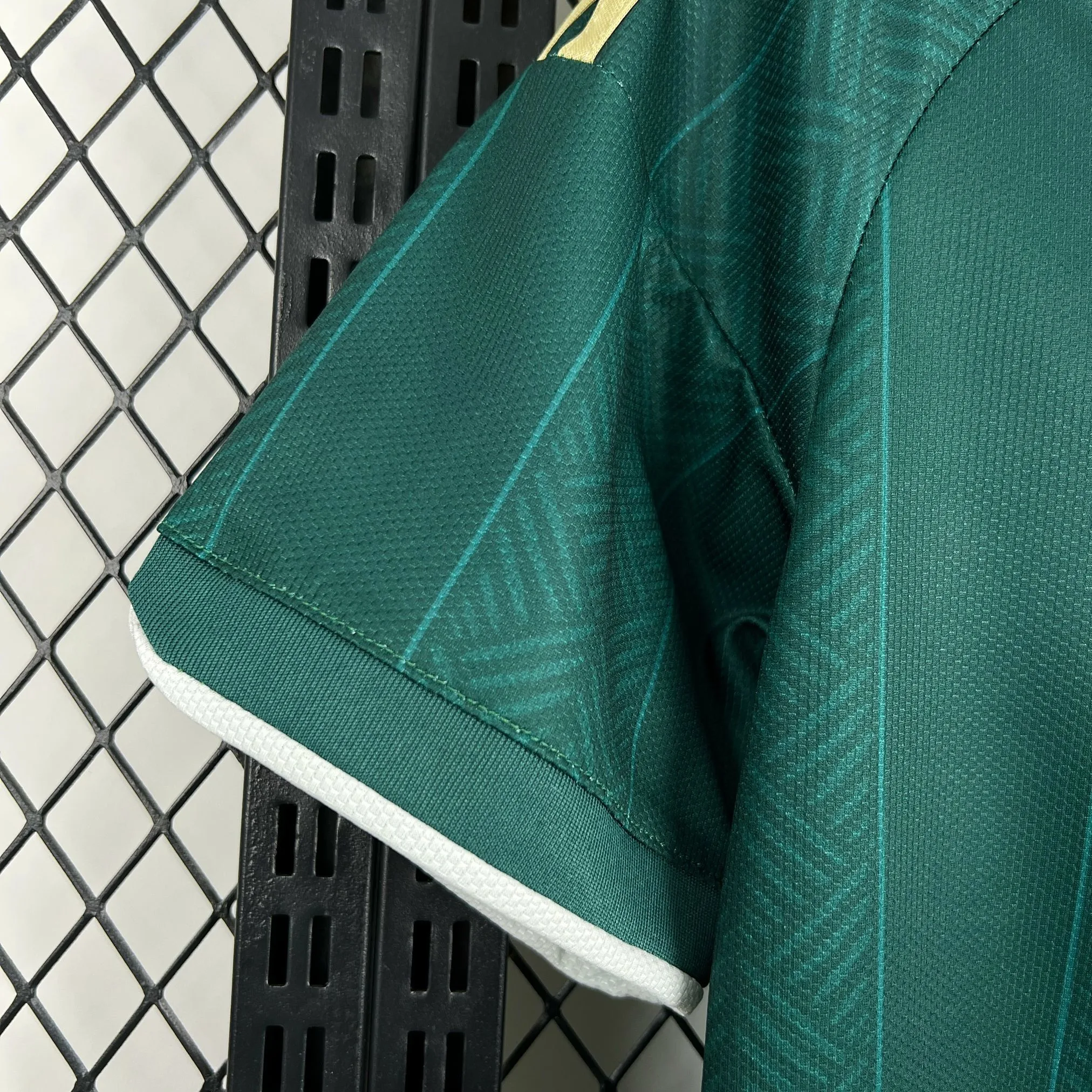 Detalle de la manga verde con un sutil patrón gráfico tonal y remate elástico de la segunda equipación sudafricana.