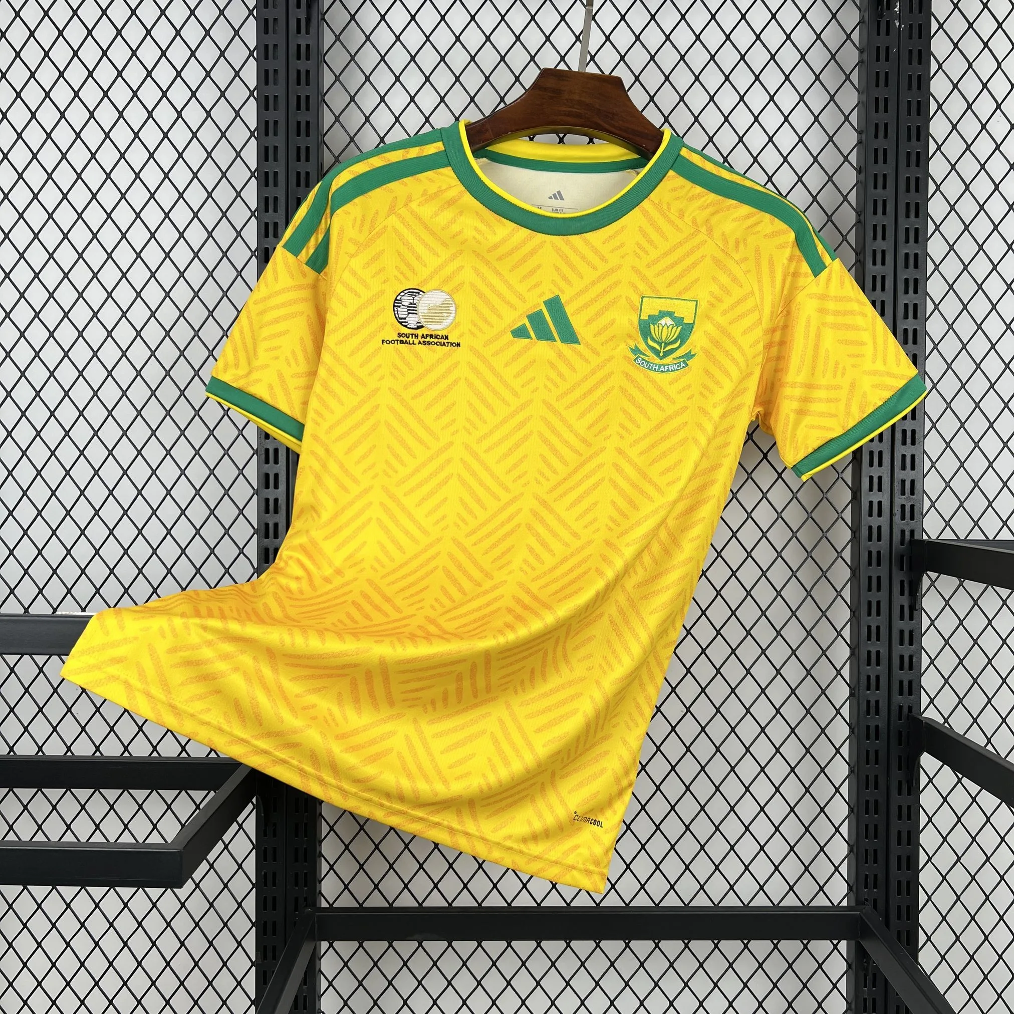 Imagen frontal completa de la camiseta local de Sudáfrica para el Mundial 2026, color amarillo con paneles laterales verdes.