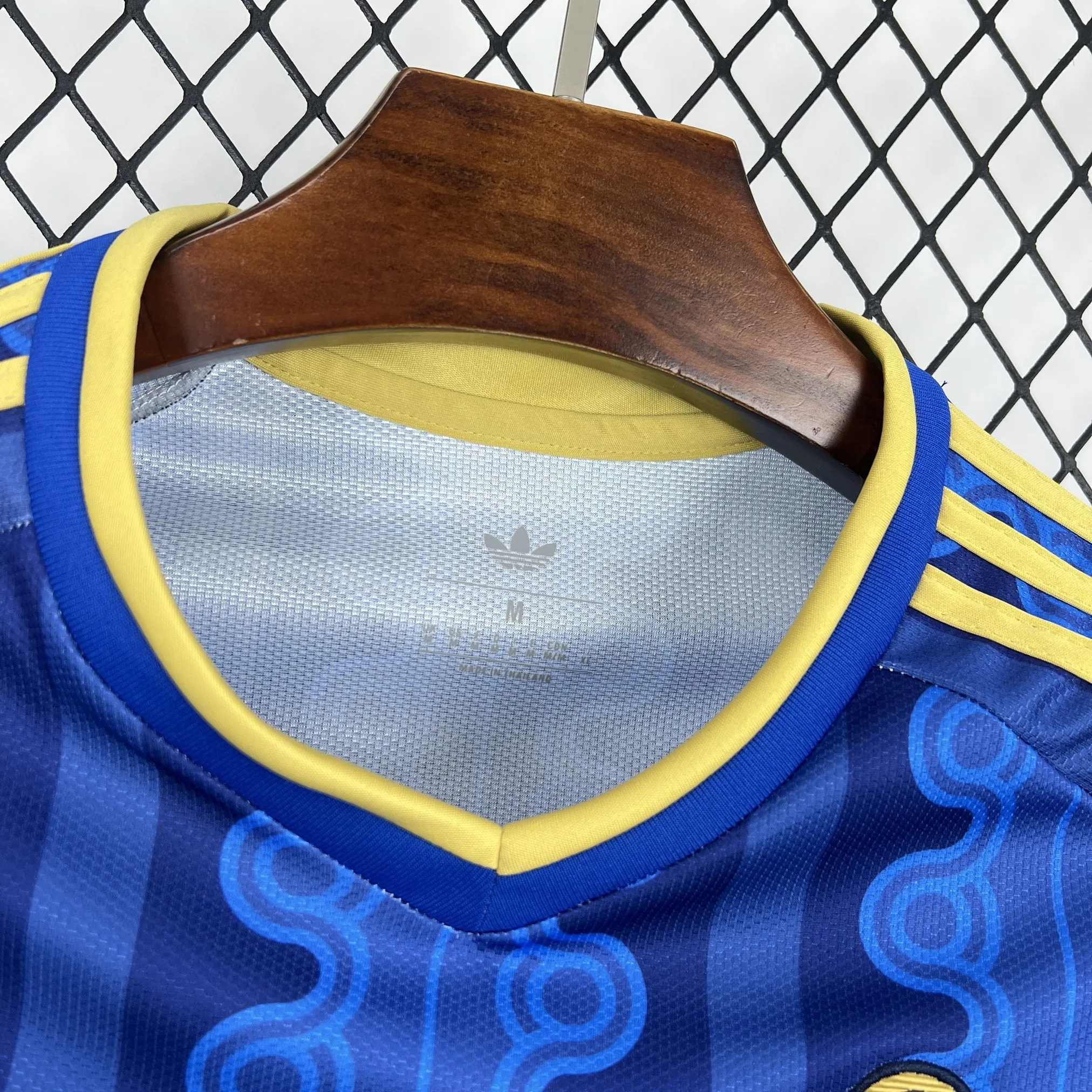 Detalle del cuello redondo en azul marino con logotipos de tecnología transpirable impresos en el interior.