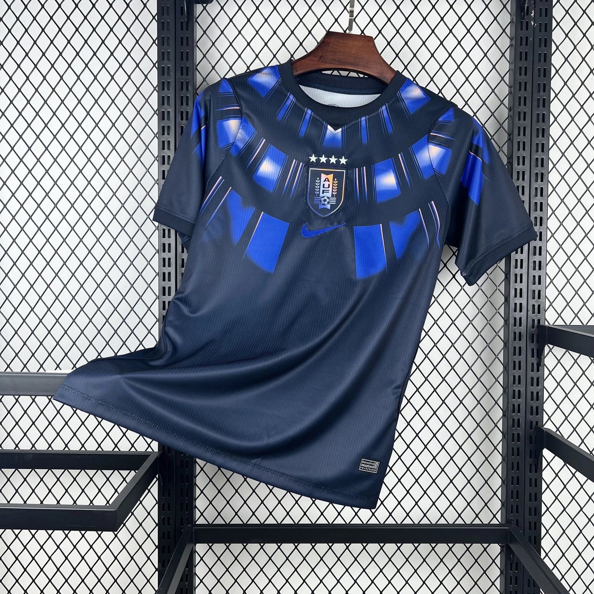 Imagen frontal completa de la camiseta de Uruguay visitante, color blanco con detalles en azul celeste y dorado en el cuello y laterales.