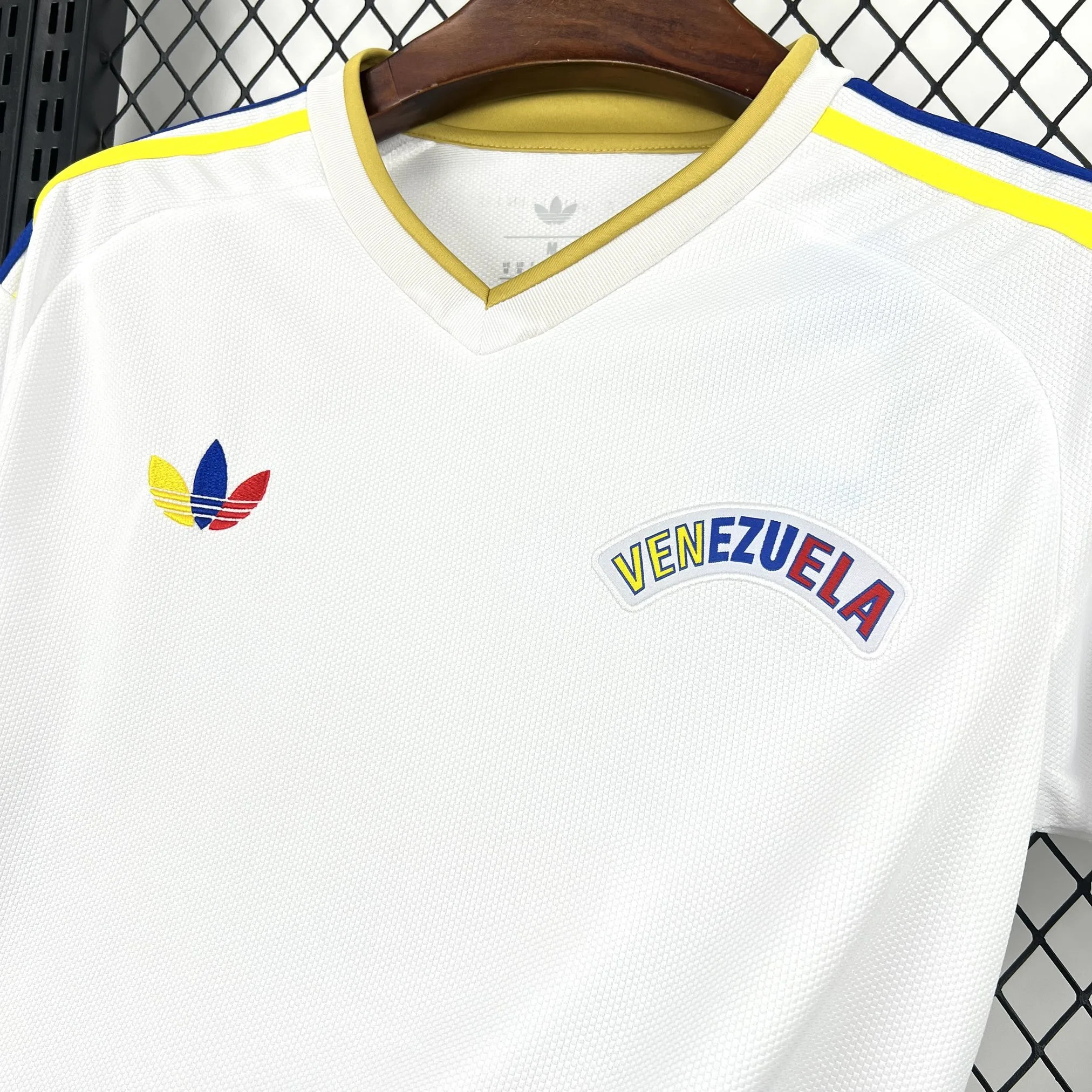 Primer plano del escudo de la Federación Venezolana de Fútbol (FVF) bordado en sus colores originales sobre fondo blanco.
