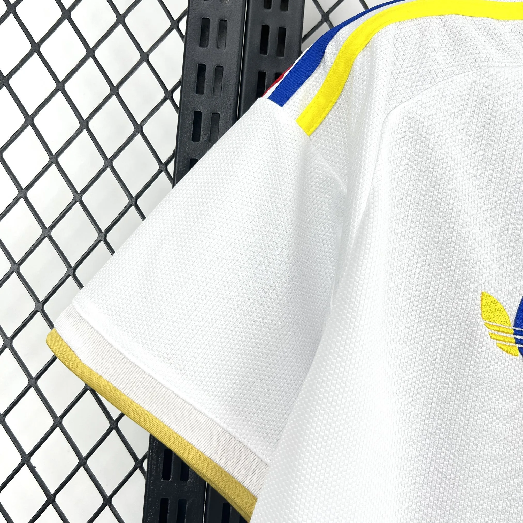 Detalle de la manga blanca con un panel lateral que muestra un degradado dinámico en color amarillo y azul.