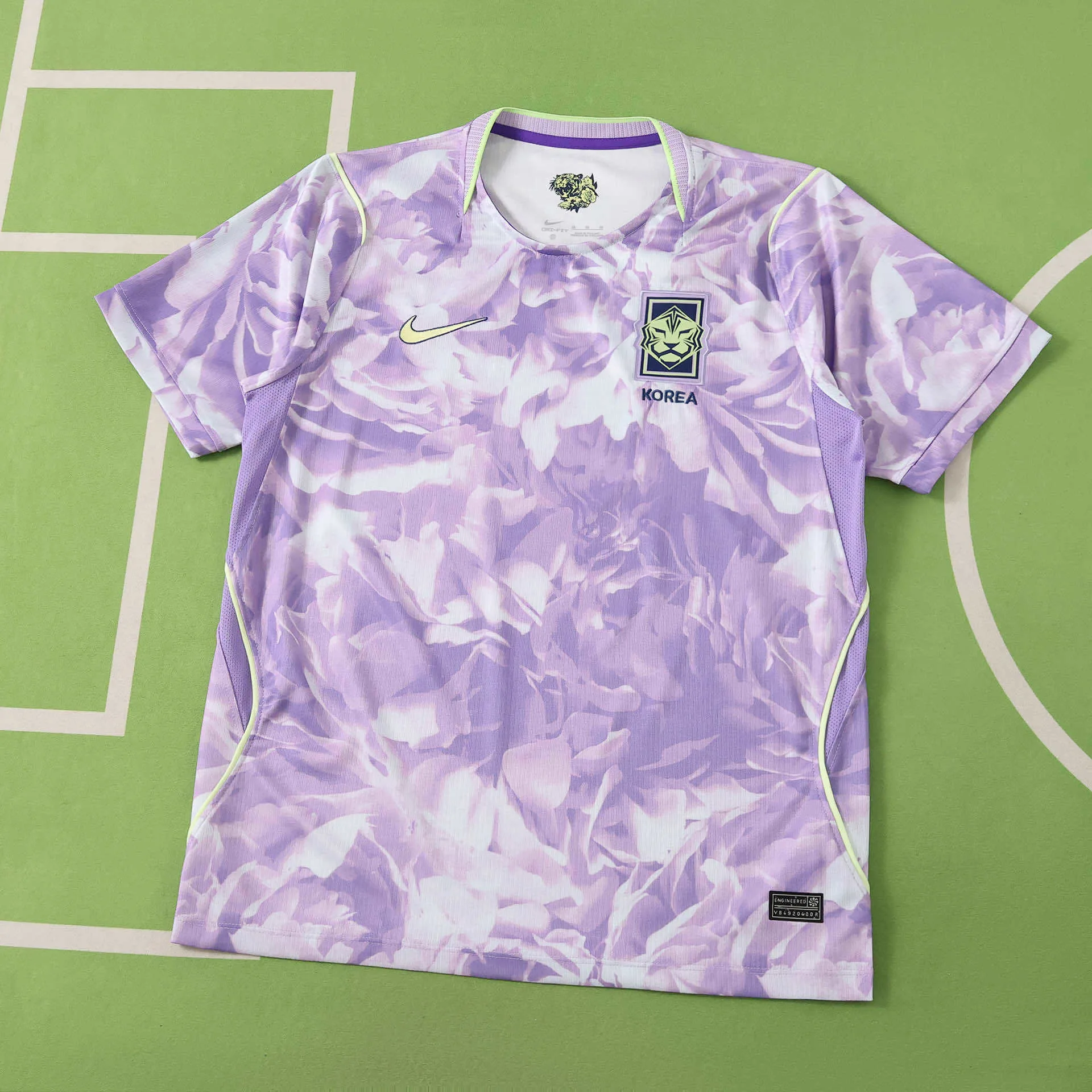 Imagen frontal completa de la camiseta visitante de Corea del Sur para el Mundial 2026, con diseño artístico en tonos púrpura y detalles verde lima.