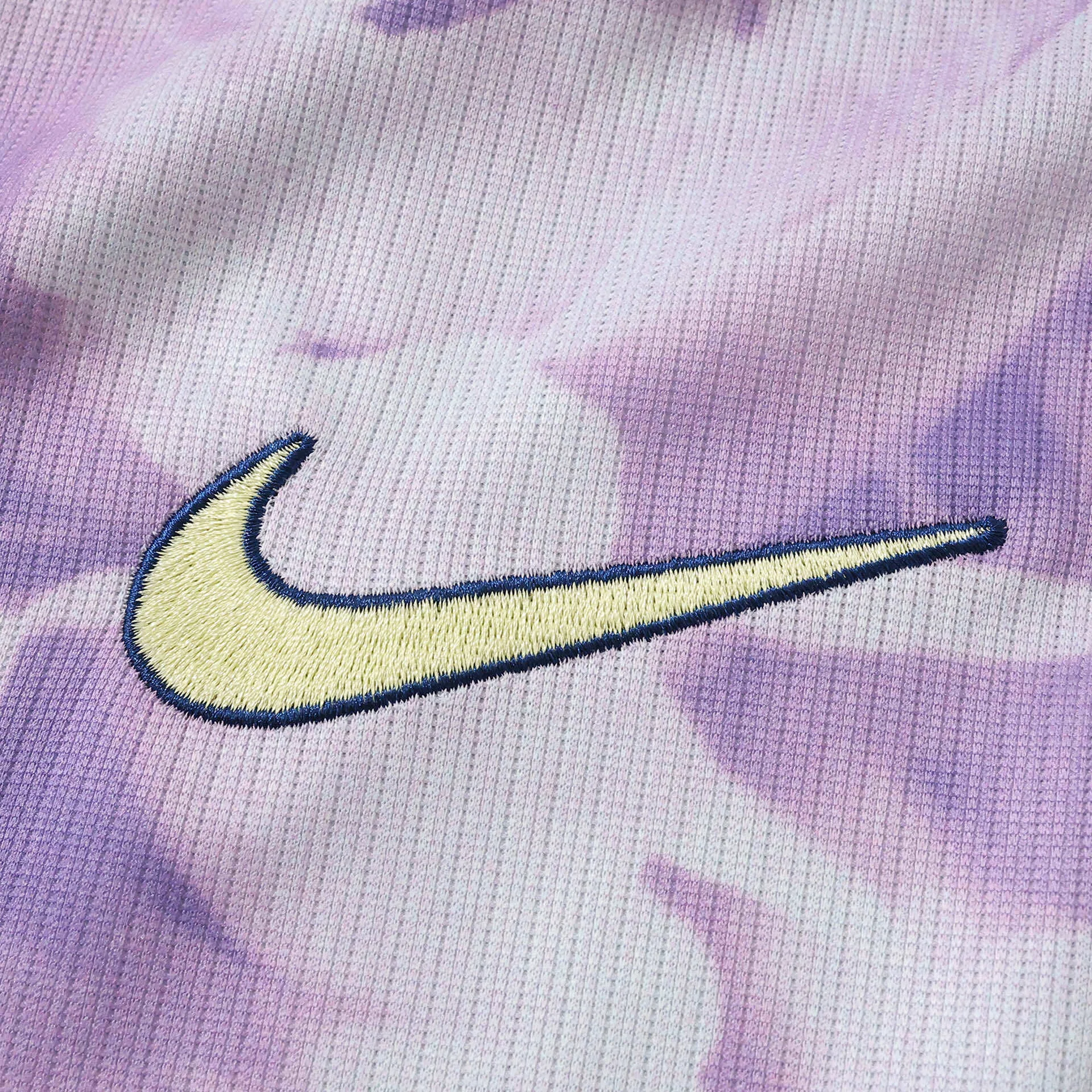 Detalle decorativo bordado en color crema sobre el tejido técnico con patrón artístico de la camiseta de Corea del Sur.