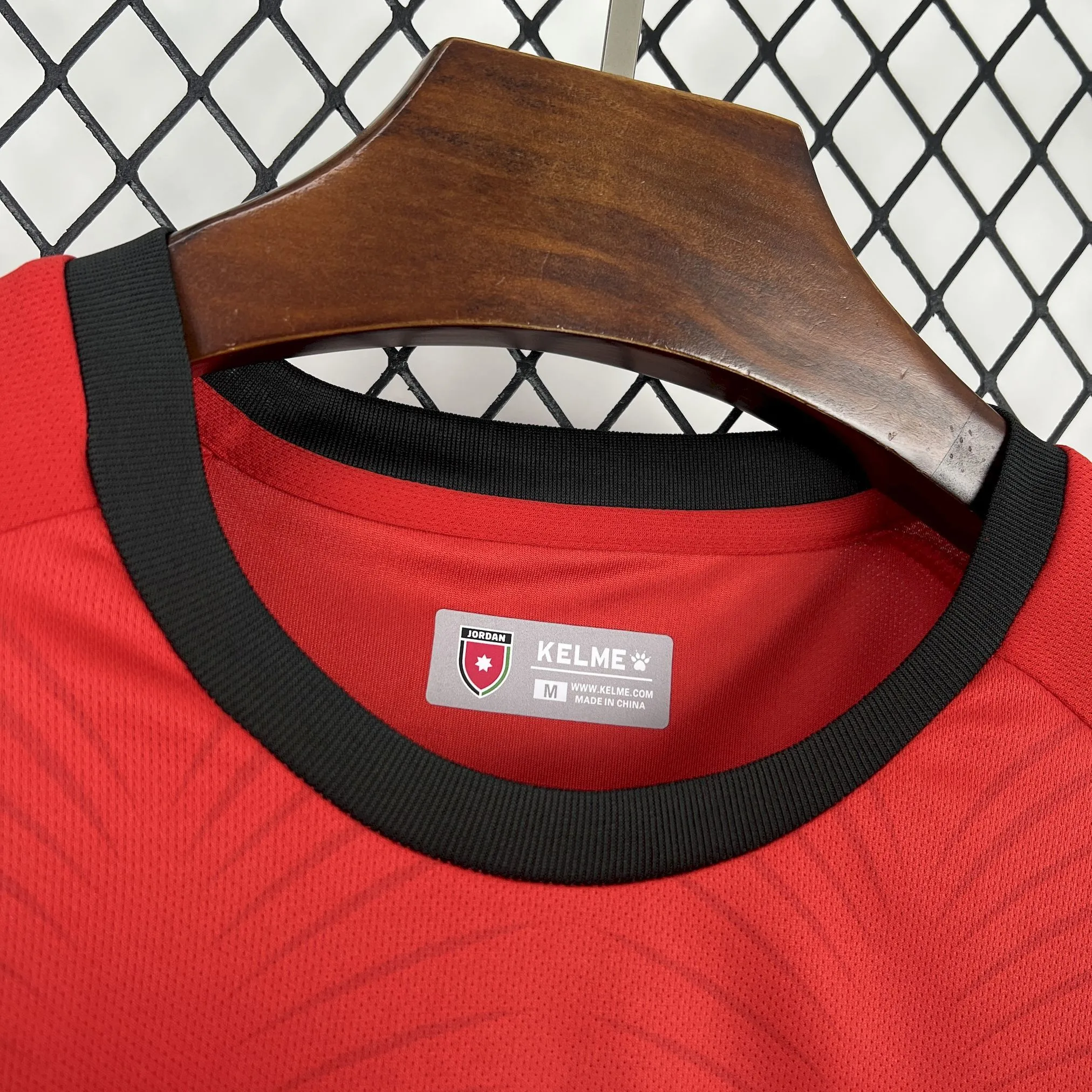 Detalle del cuello redondo negro con vivos en color rojo y logotipos de tecnología impresos en el interior.