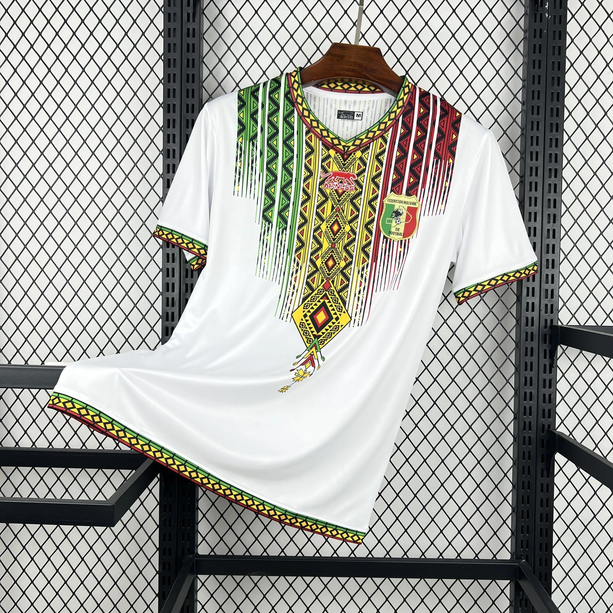 Imagen frontal completa de la camiseta local de Mali, color verde vibrante con un gran gráfico de águila tricolor en el pecho.