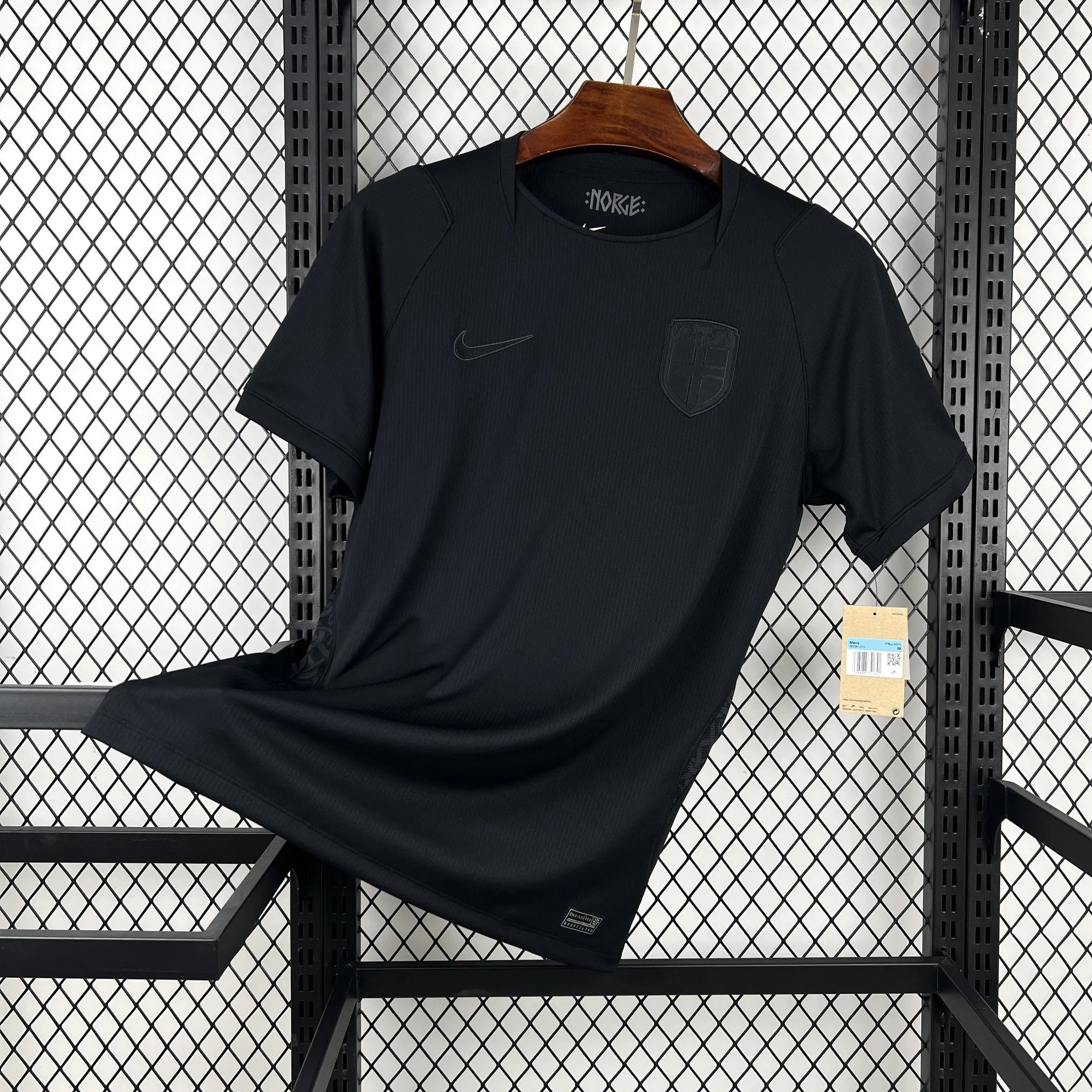 Imagen frontal completa de la camiseta visitante de Noruega, color blanco con un llamativo patrón gráfico de degradados azules y rojos.