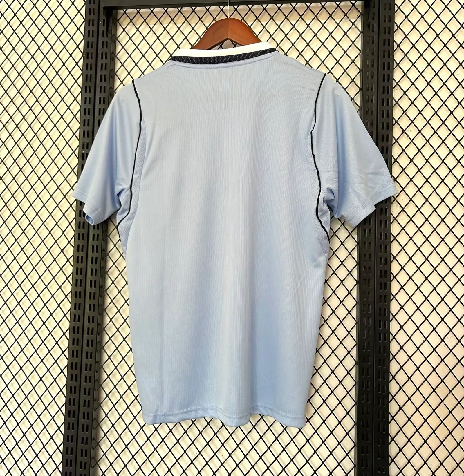 Vista posterior de la camiseta de Uruguay 2026, diseño clásico en color celeste con paneles laterales de ventilación.