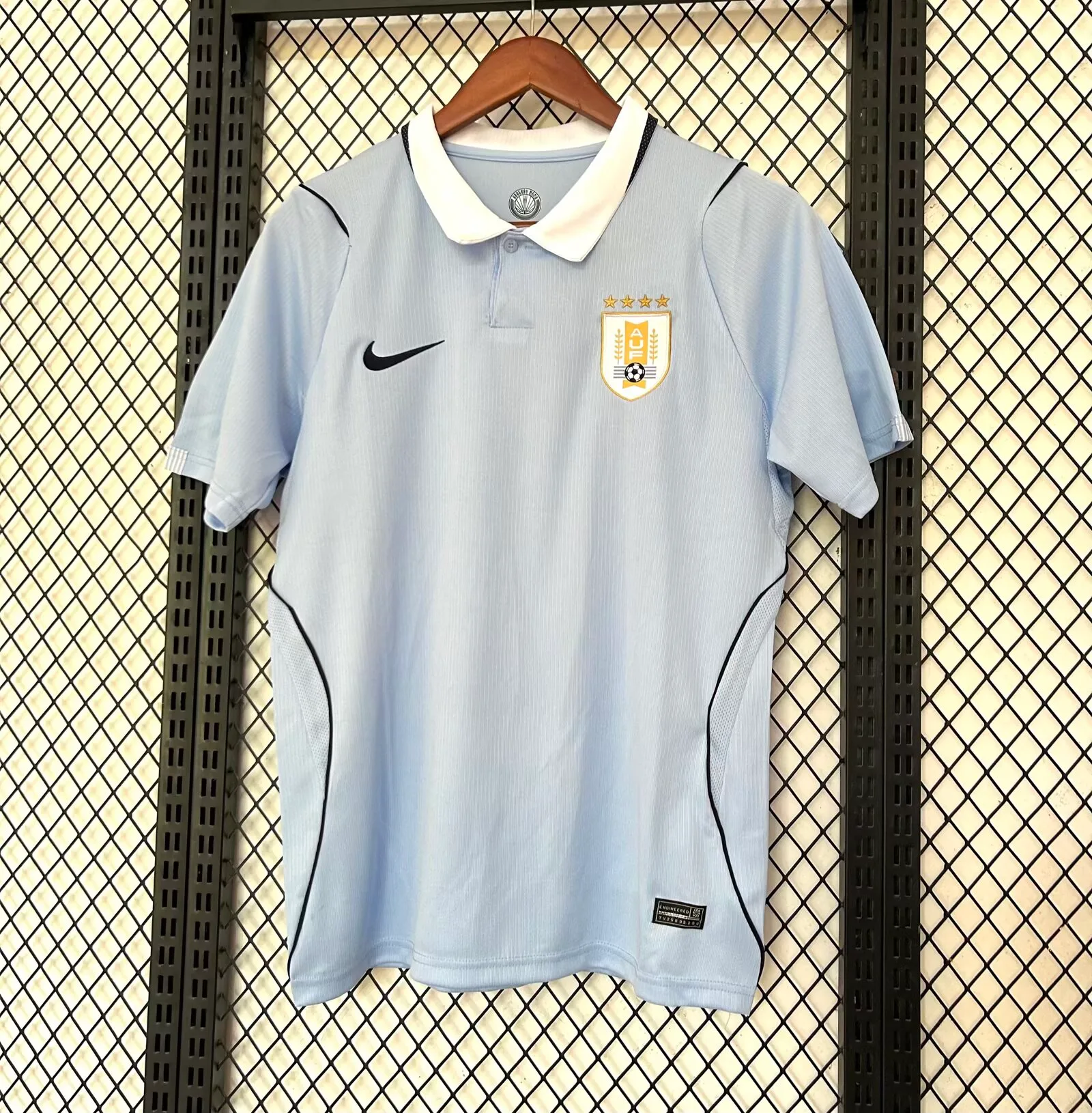 Imagen frontal completa de la camiseta local de Uruguay para el Mundial 2026, color azul celeste con detalles en blanco y negro.